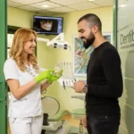 Doktorka Ljubica Stefanović u stomatološkoj ordinaciji Dentib, koristeći prozirni anatomski model vilice, objašnjava pacijentu sa bradom ključnu vezu između umnjaka i fiksne proteze, ukazujući na potencijalni pritisak umnjaka na poravnate zube