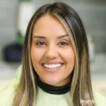 Nasmejana devojka pokazuje prirodne rezultate nakon postavljanja faseta na potamnele zube u stomatološkoj ordinaciji Dentib.