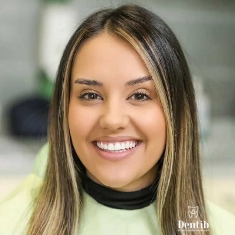 Nasmejana devojka pokazuje prirodne rezultate nakon postavljanja faseta na potamnele zube u stomatološkoj ordinaciji Dentib.